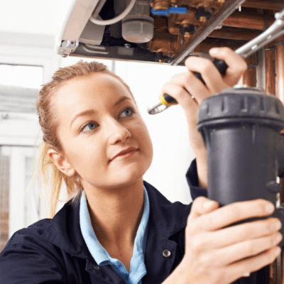 Female plumber inspecting drain pipe